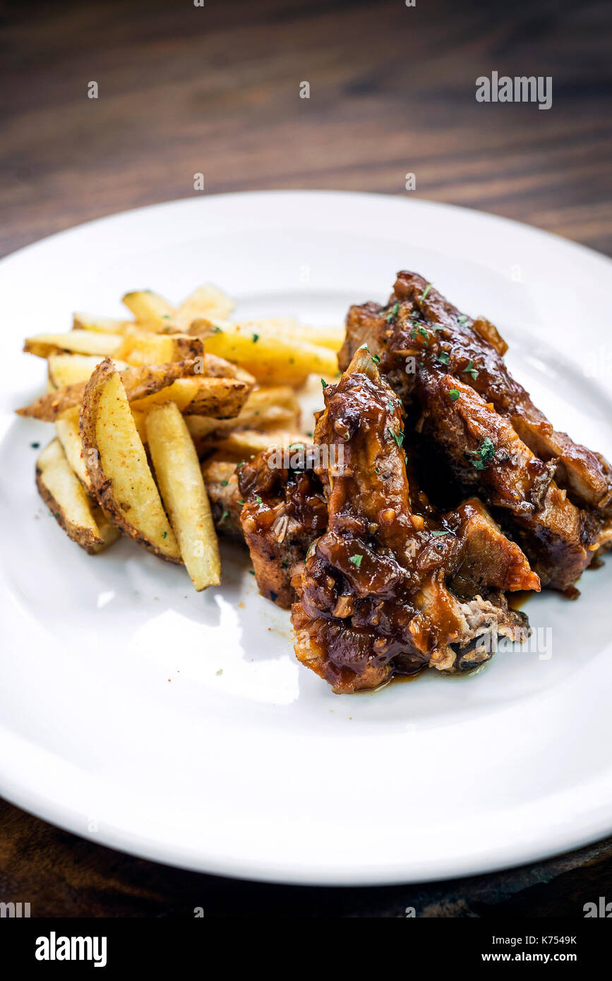 spicy bbq barbecue pork spare ribs with wedges french fries Stock Photo