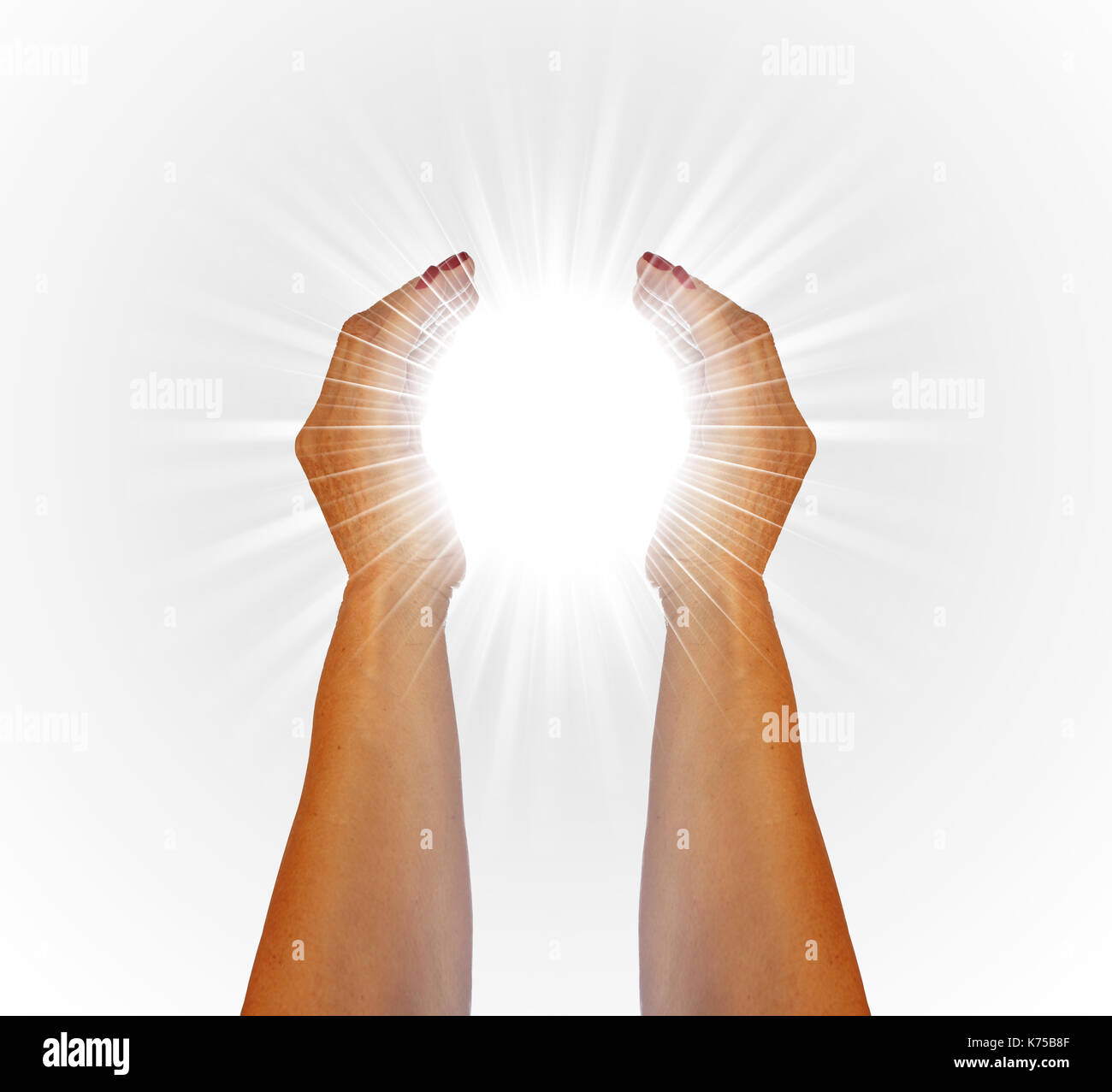 Rays of white light between the hands of a woman on white background Stock Photo