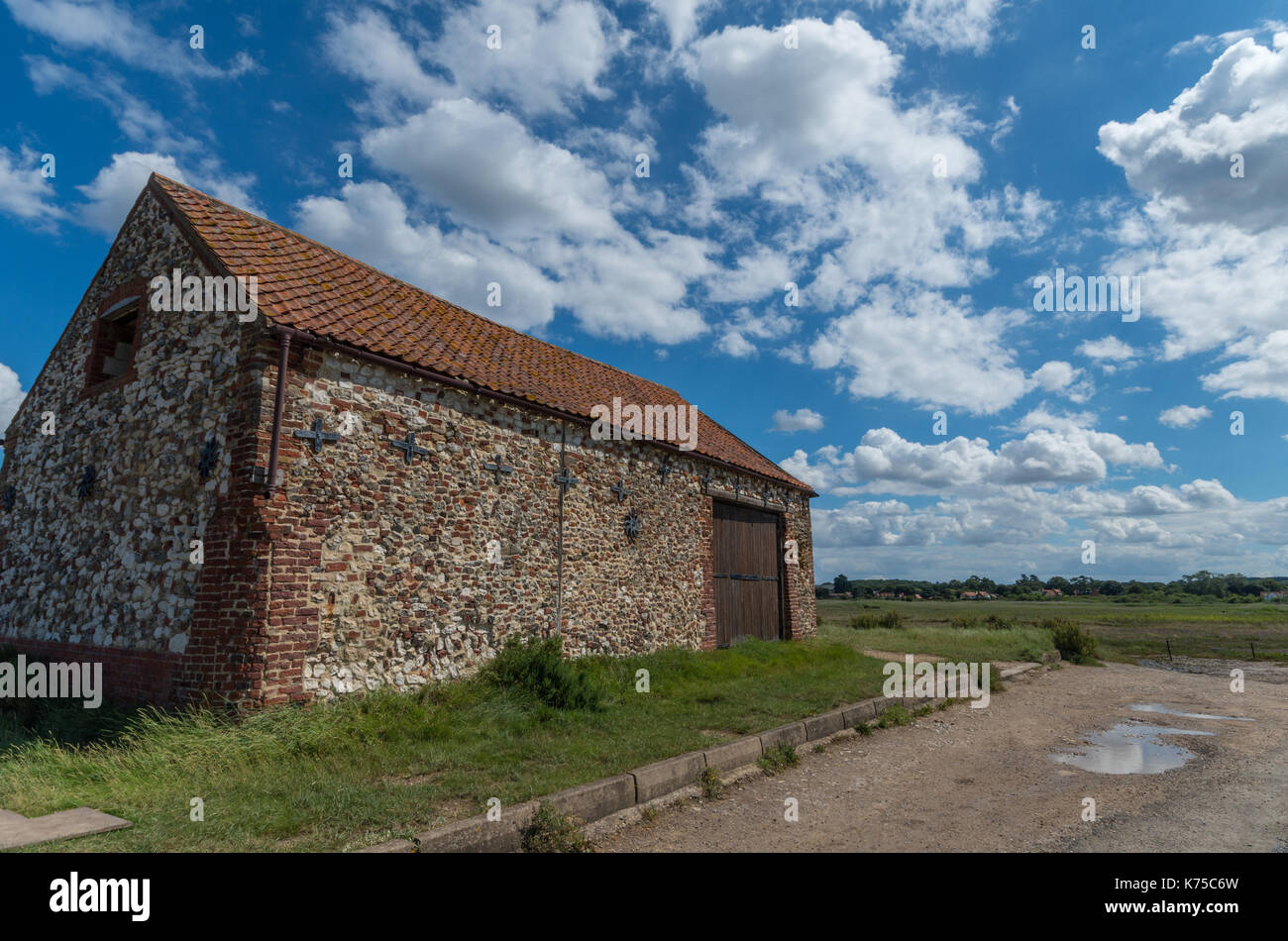 The Coal Barn, a former warehouse, set on the salt marshes at Thornham Harbour, Norfolk, UK; a favourite subject for artists. Stock Photo