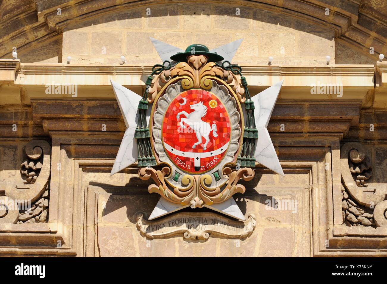 Malta, Birgu Vittoriosa, Church of Saint Lawrence of Birgu built in 1697, detail of the facade of 1696 with cross of Malta and hat of the papacy Stock Photo