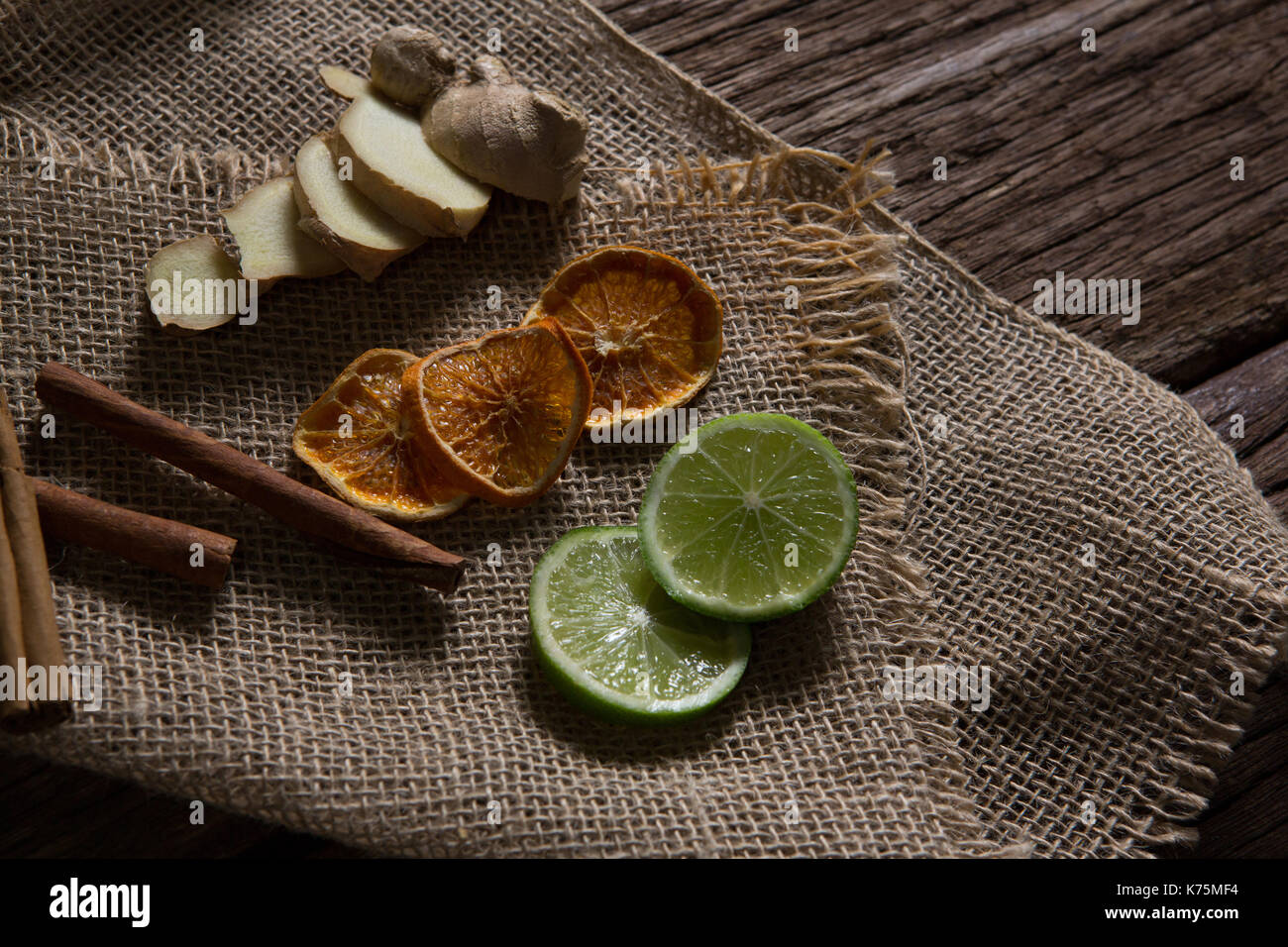 Close-up of sliced ginger, dried orange and lemon with cinnamon stick on textile Stock Photo