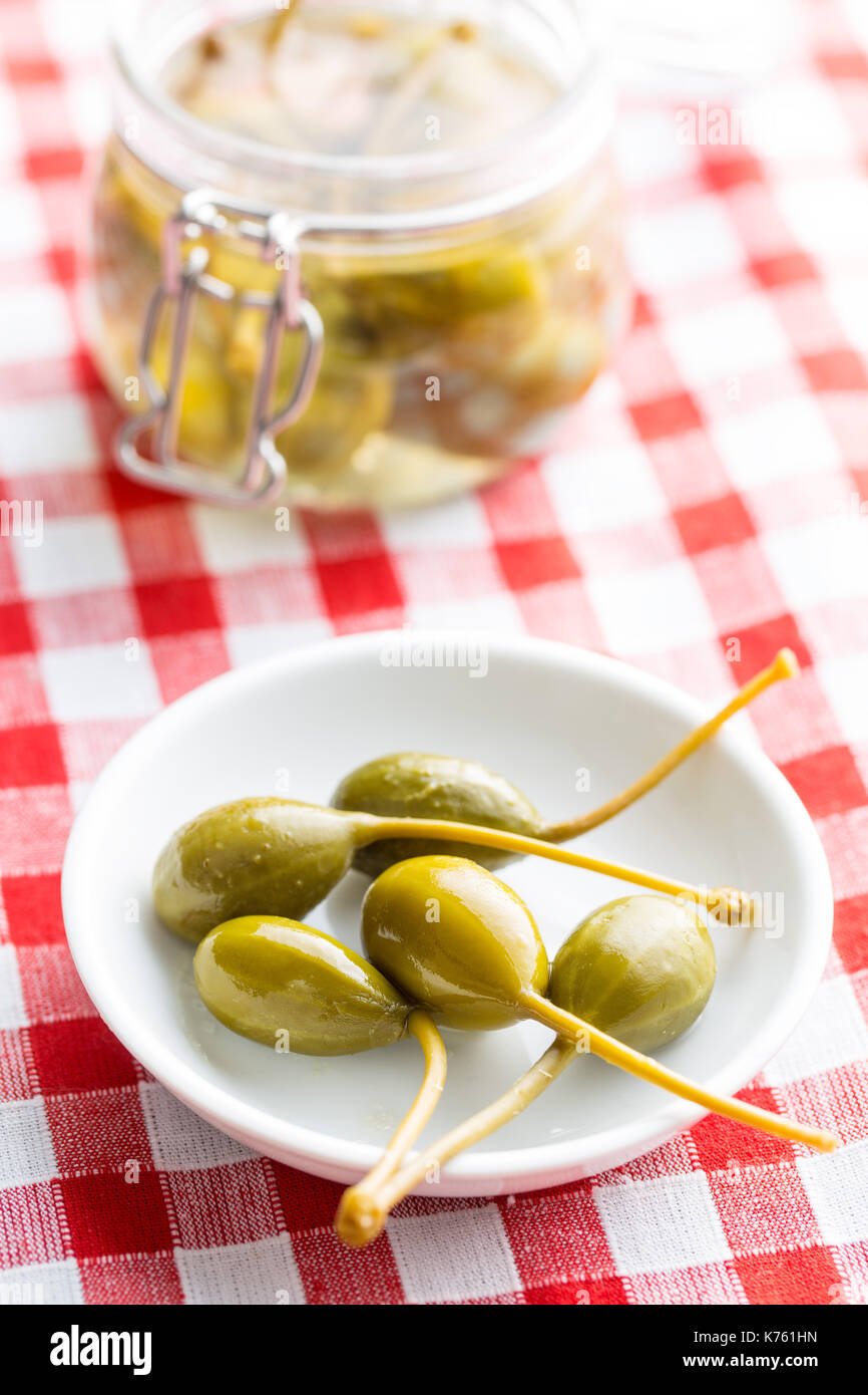 Pickled caper berries in bowl on checkered tablecloth Stock Photo Alamy