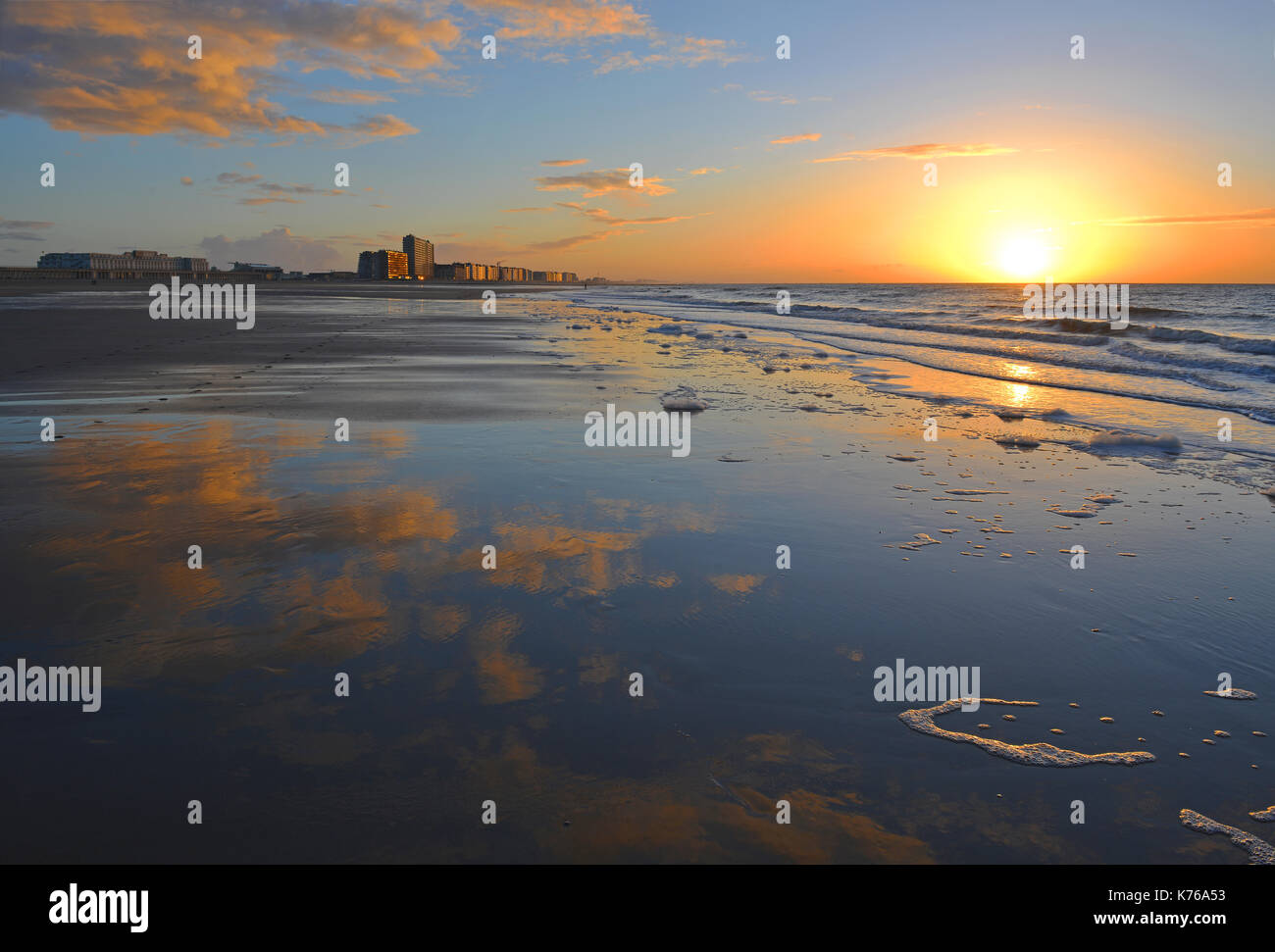 Reflection of a sunset in the North Sea by the beach city of Ostend with its famous skyline, West Flanders, Belgium. Stock Photo