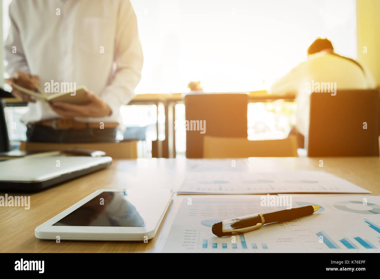 Image of business documents on workplace with two partners interacting ...