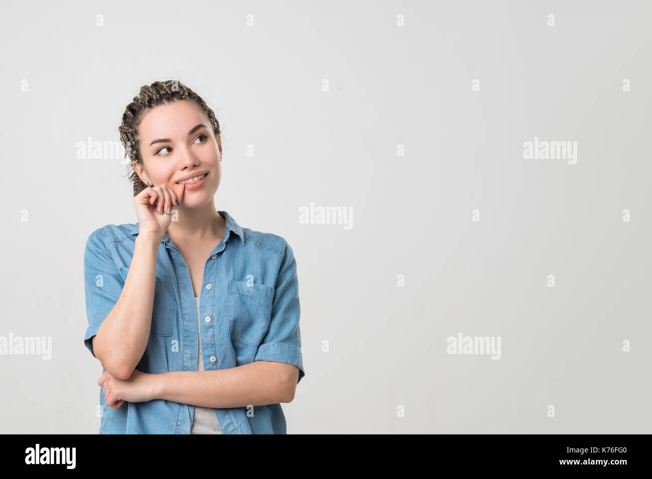 Laughing caucasian woman with braids hairstyle and good sense of humor smiling dreamly Stock Photo