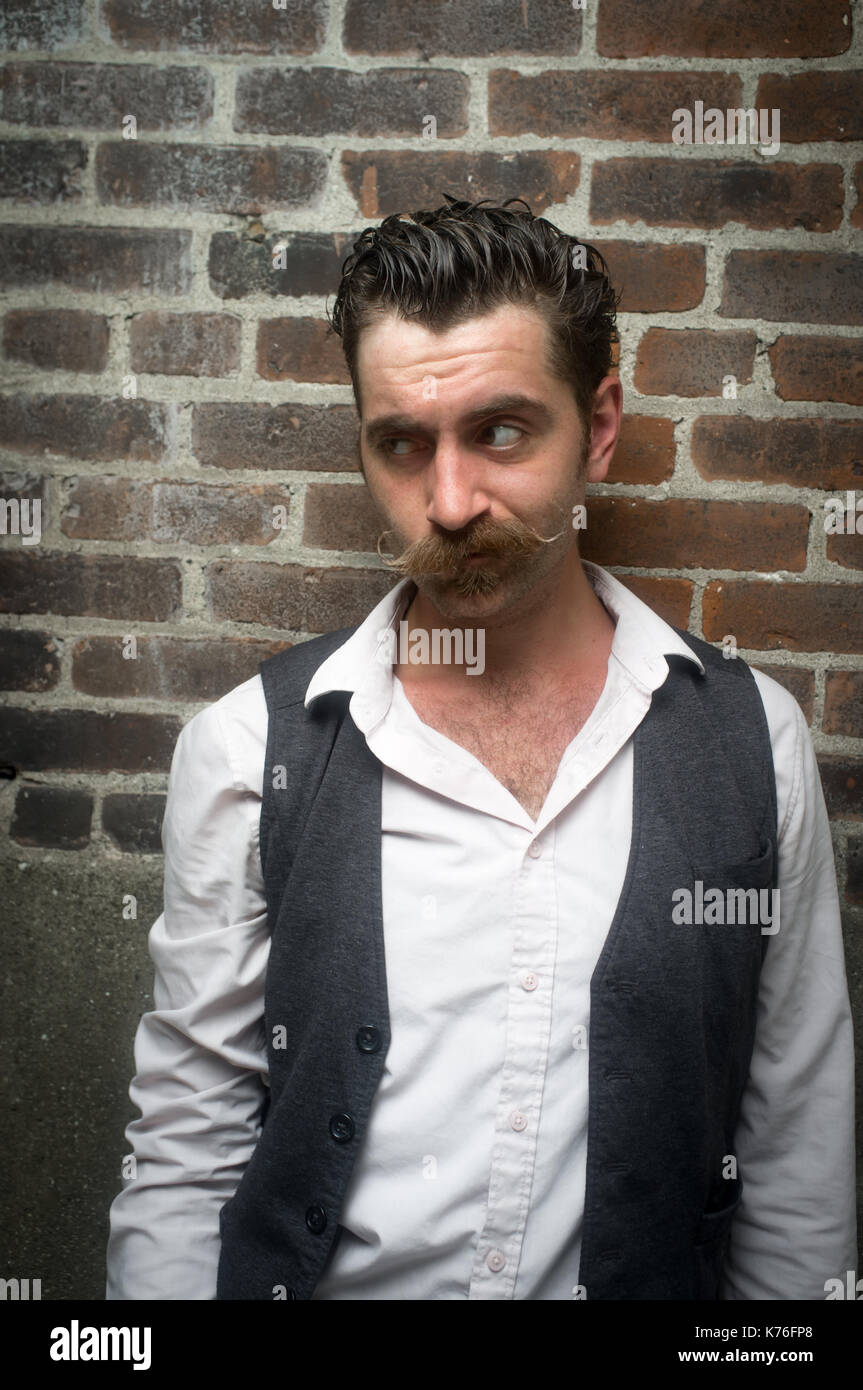 Caucasian hipster man with large handlebar mustache wearing a dress shirt  and suit vest Stock Photo - Alamy