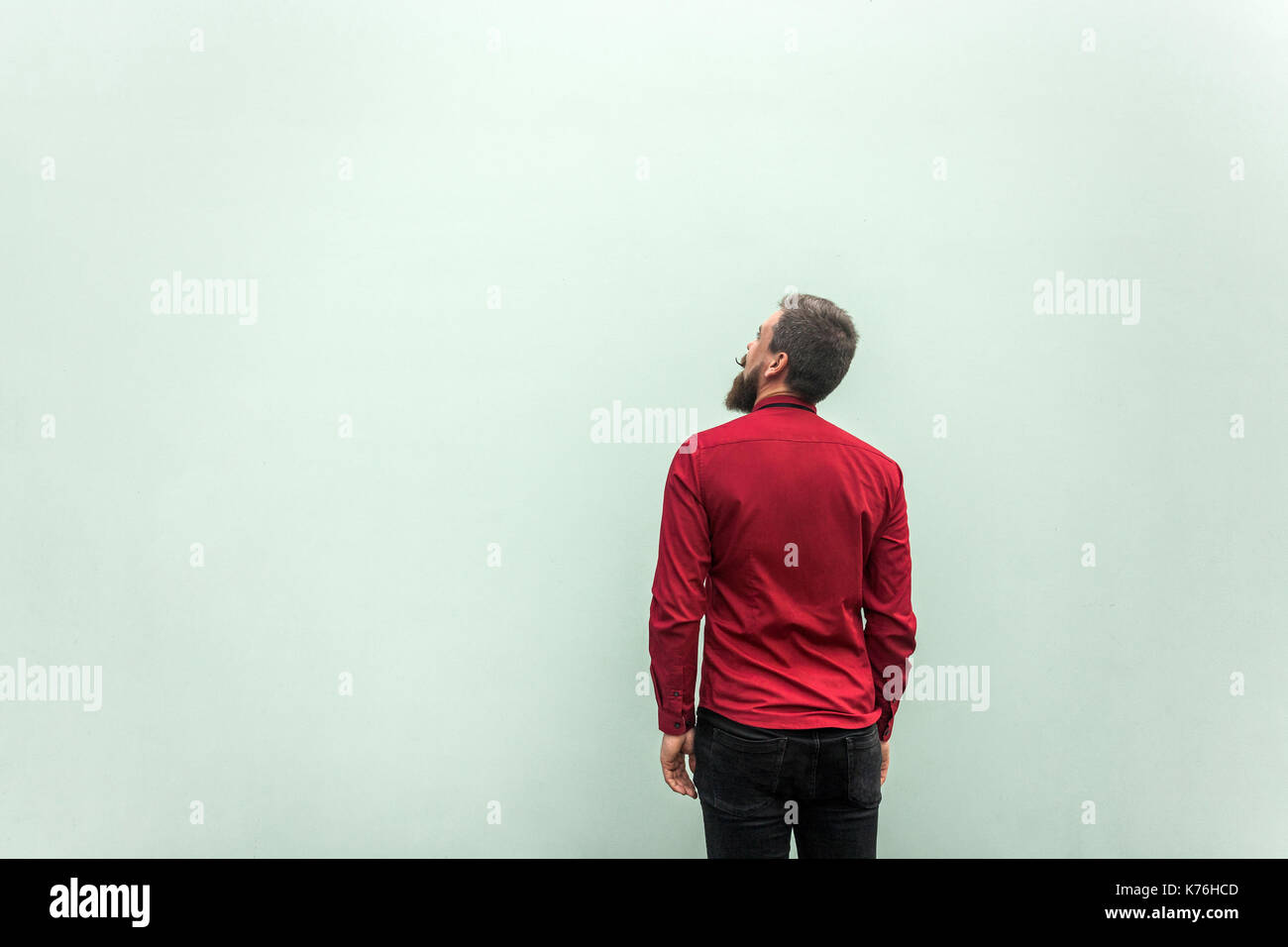 Back view of a sucess businessman, on gray background. Looking up and dreaming. Studio shot, gray background Stock Photo