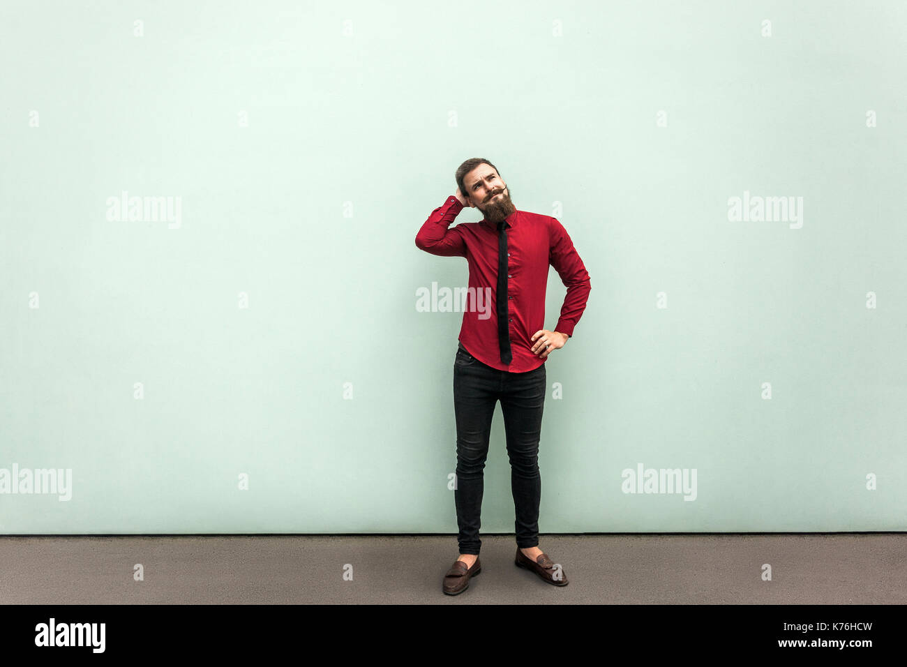 Lets my think. Confusion young ault businessman. Gray wall, outdoor Stock Photo