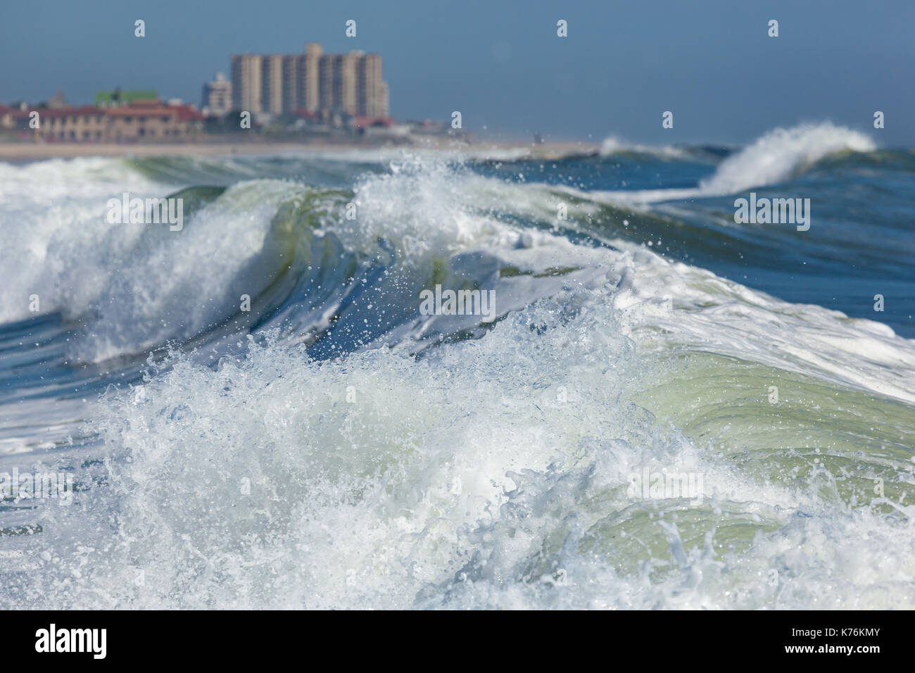 Waves crash near the shore in Deal, New Jersey. Long Branch is visible in the background. Stock Photo