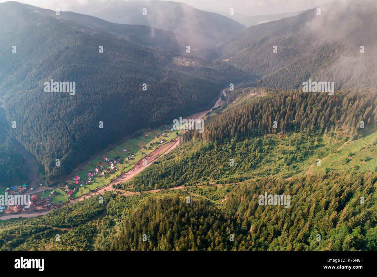 Aerial view of the village in the Carpathian mountains with clouds in ...