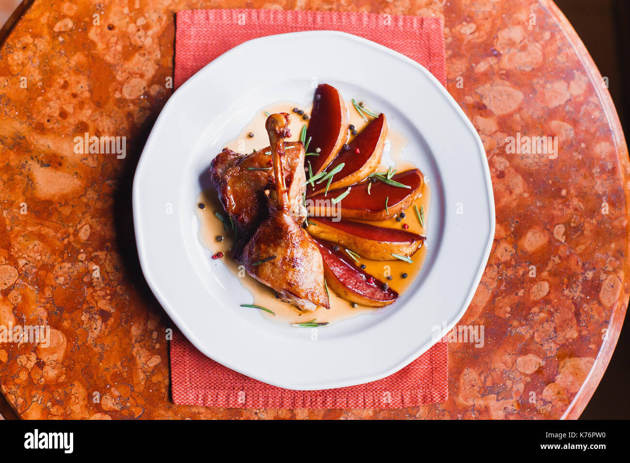 The above view of the fried potatoes and grilled chicken placed on the white plate in the restaurant. Stock Photo