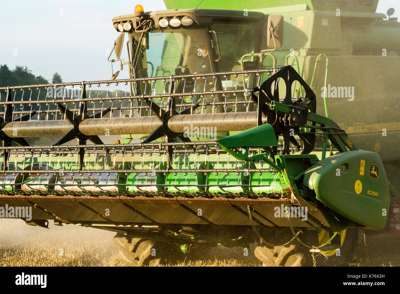 Close up of the front of a combine harvester with a raised header showing the reel and cutter bar, Nottinghamshire, England, UK Stock Photo