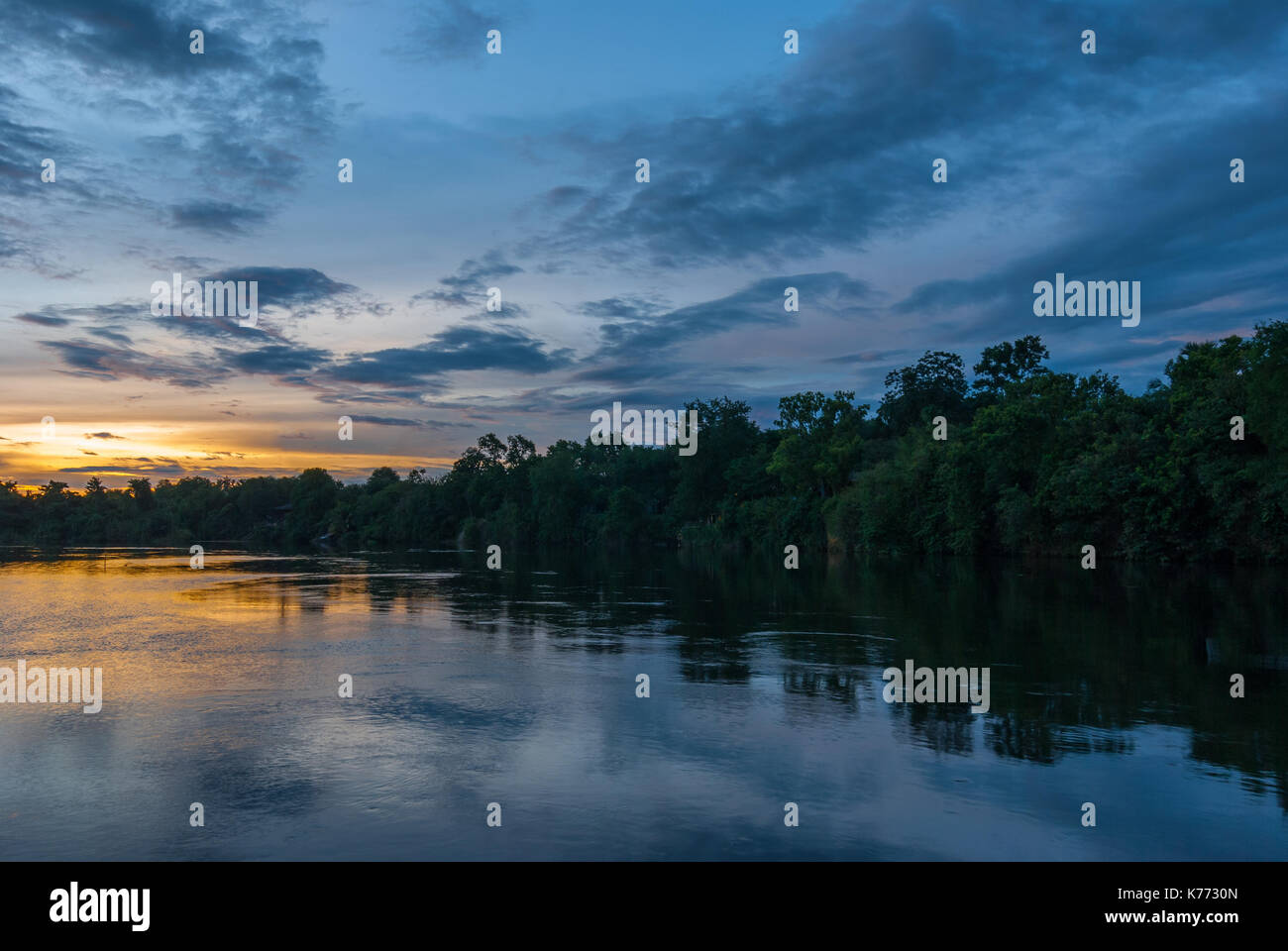 Sunset along the banks of the Amazon river.The tributaries of the Amazon traverse the countries of Guyana, Ecuador, Peru, Brazil, Colombia, Venezuela. Stock Photo
