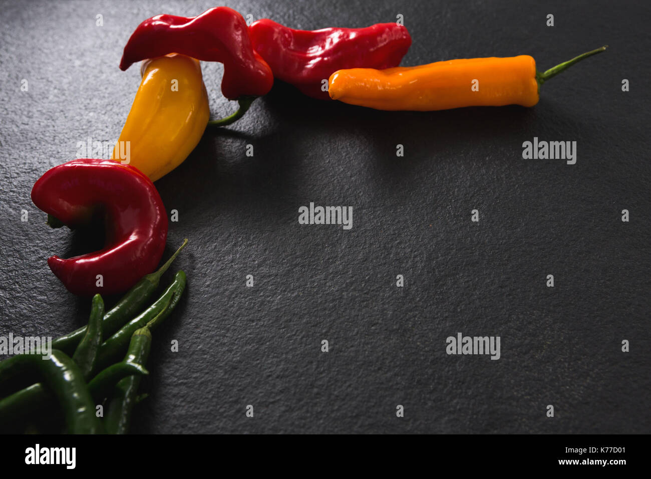Yellow, green and red chili pepper on black background Stock Photo - Alamy