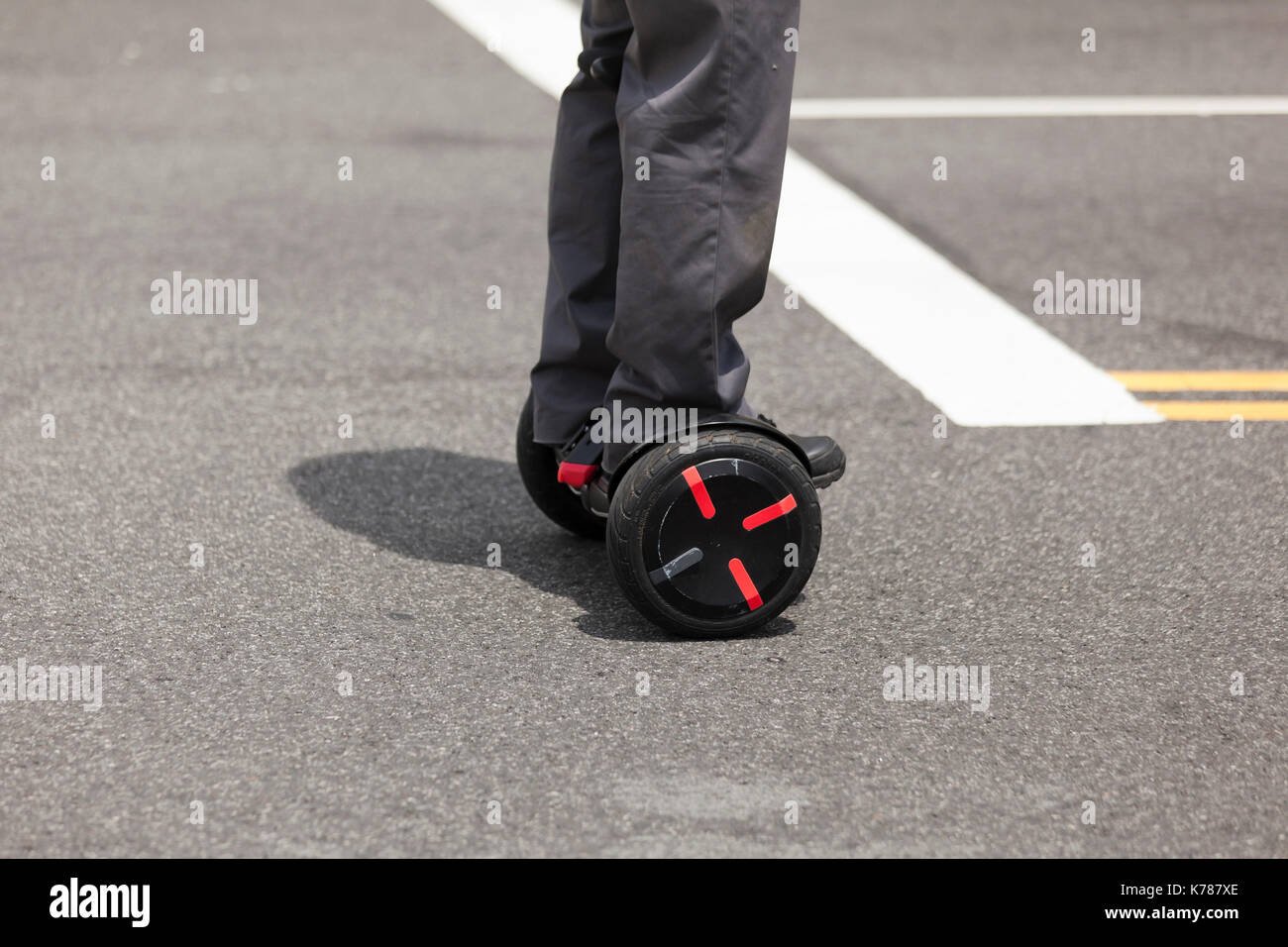 Man riding hoverboard on roadway (self balancing electric scooter) - USA Stock Photo