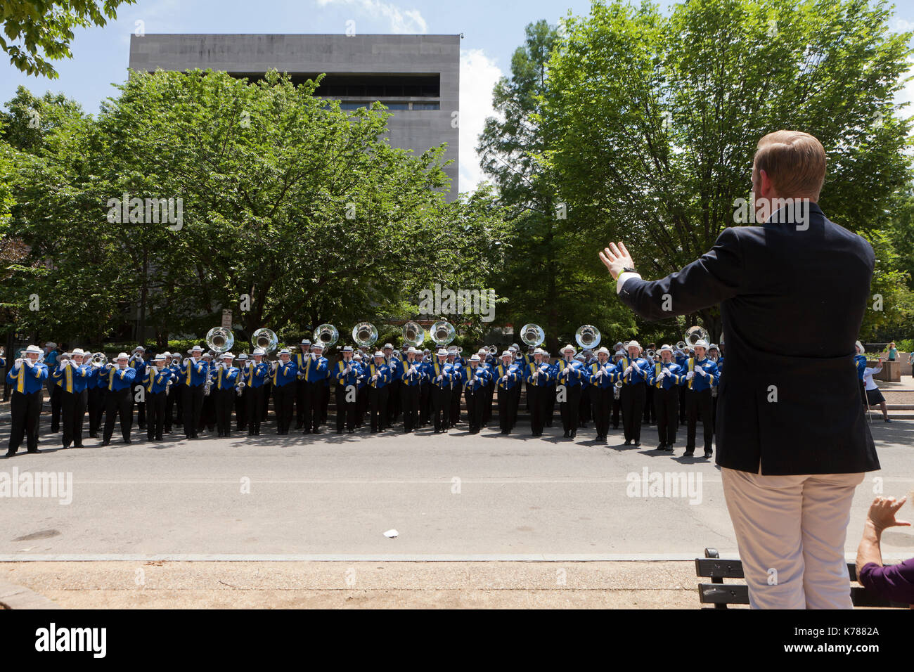 High school marching band teacher and students practicing for a parade