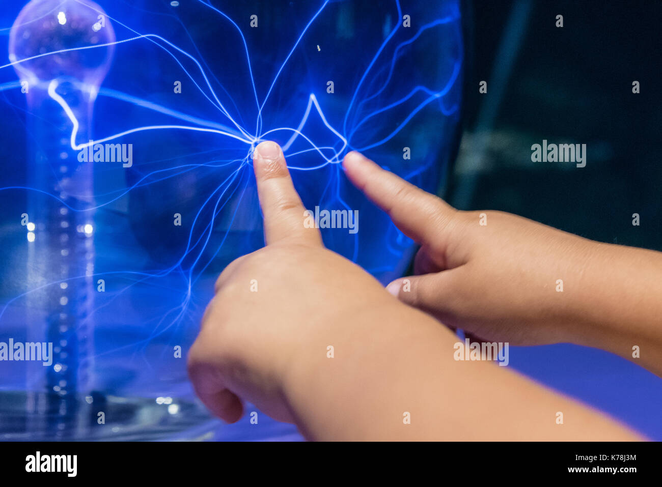 Small child touching a plasma sphere at Fernbank Museum in Atlanta, Georgia. (USA) Stock Photo