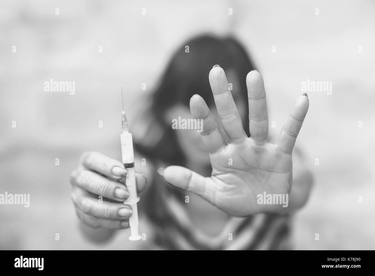 Drug addict young woman with syringe in action, Drug abuse concept. Stock Photo