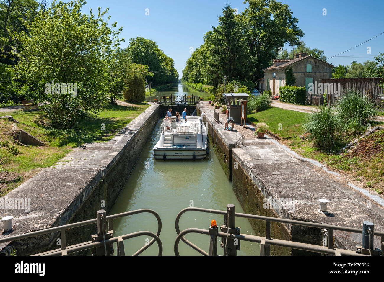 Canal boat navigating a lock on the canal latéral à la Garonne in the Dordogne region of southwest France. Stock Photo