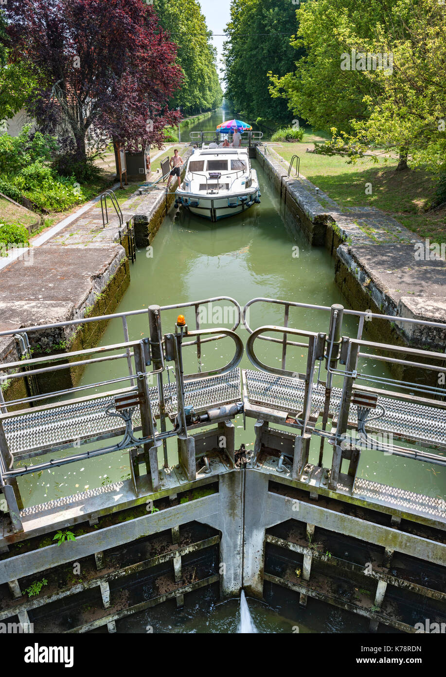 Canal boat navigating a lock on the canal latéral à la Garonne in the Dordogne region of southwest France. Stock Photo