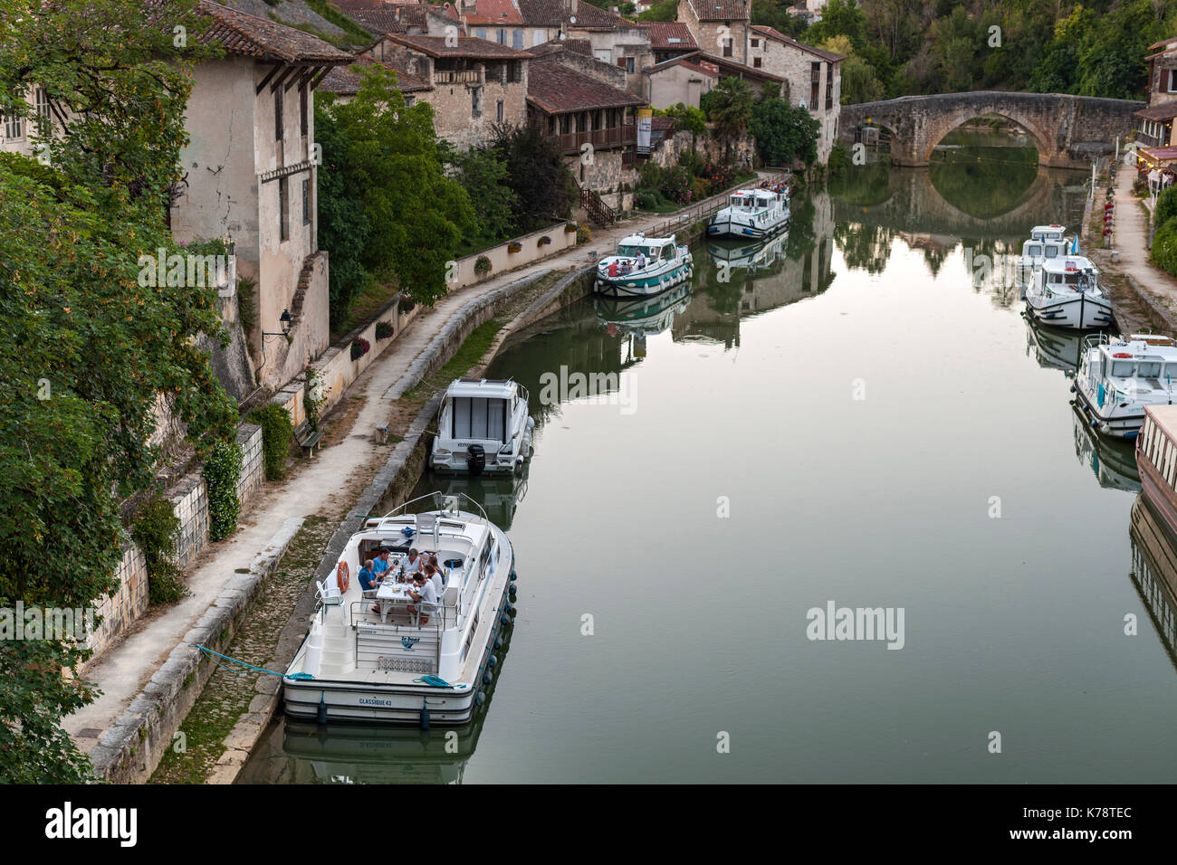 Canal boats on the Petite Baïse River in the town of Nérac in the Dordogne region of southwest France. Stock Photo