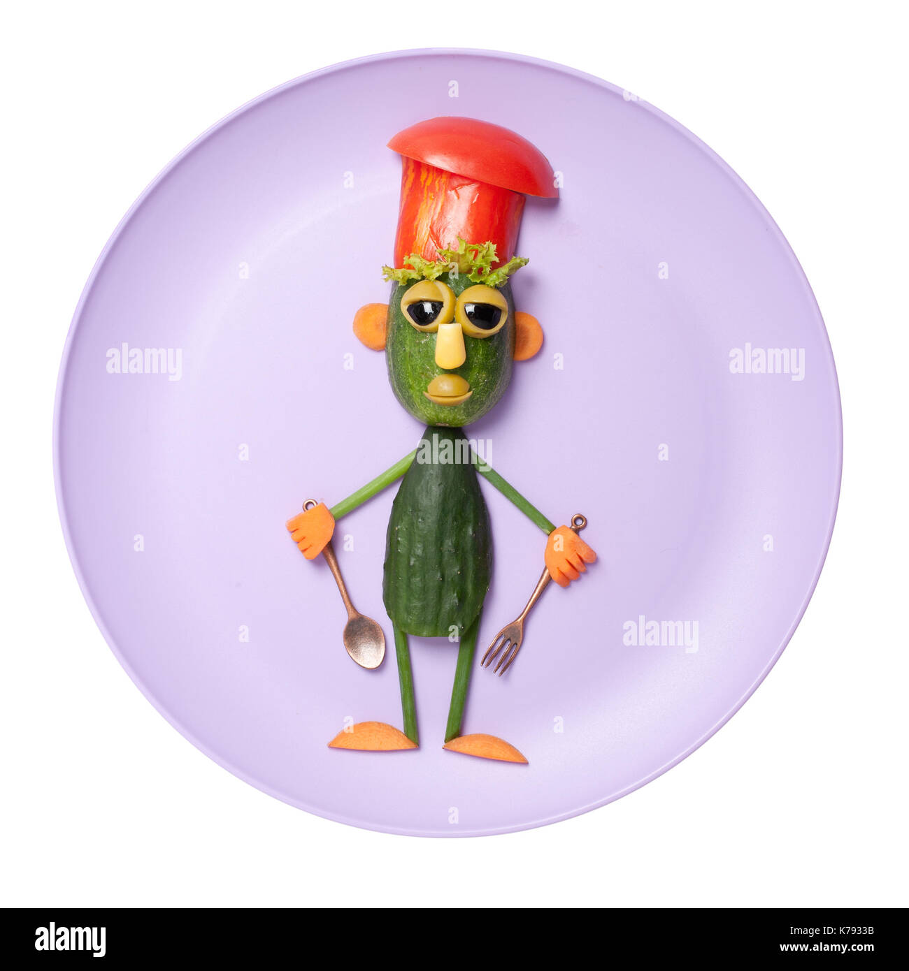 Funny cucumber chief made on purple plate Stock Photo