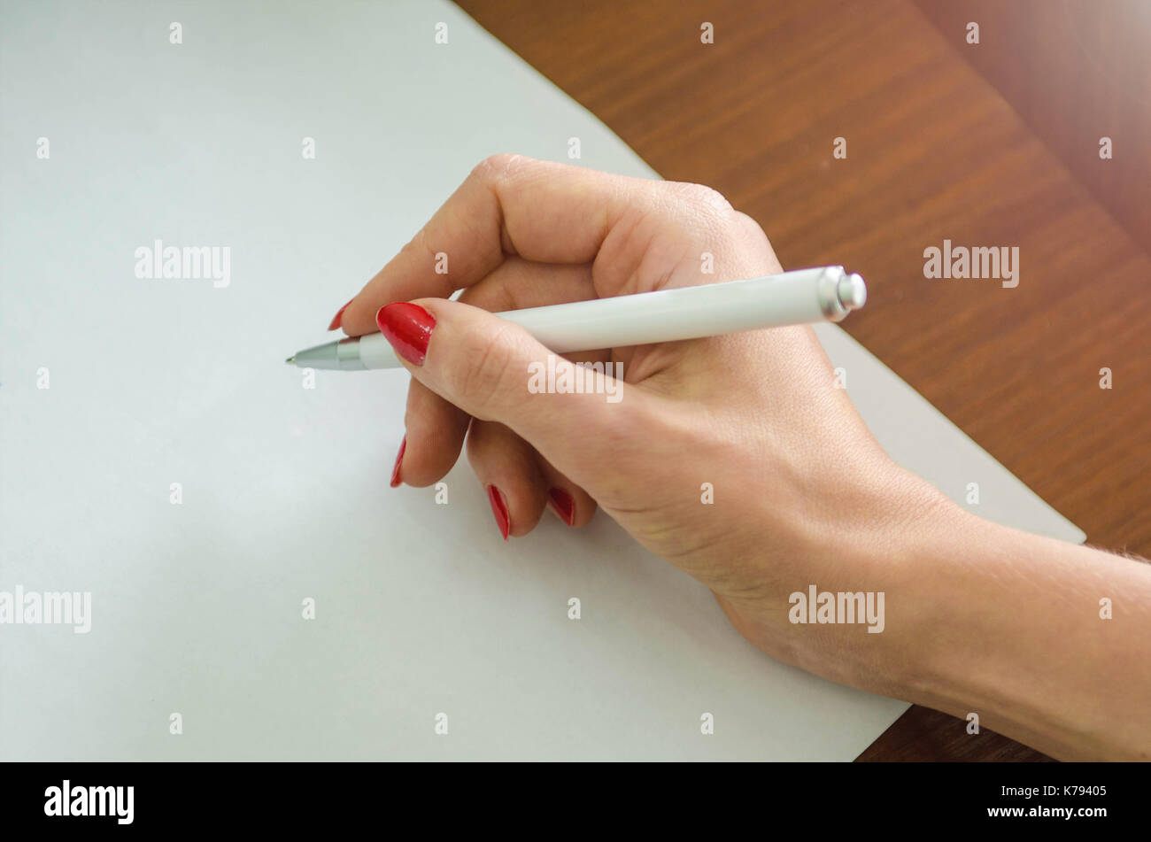 girl with a pen in her hand and a piece of paper Stock Photo - Alamy