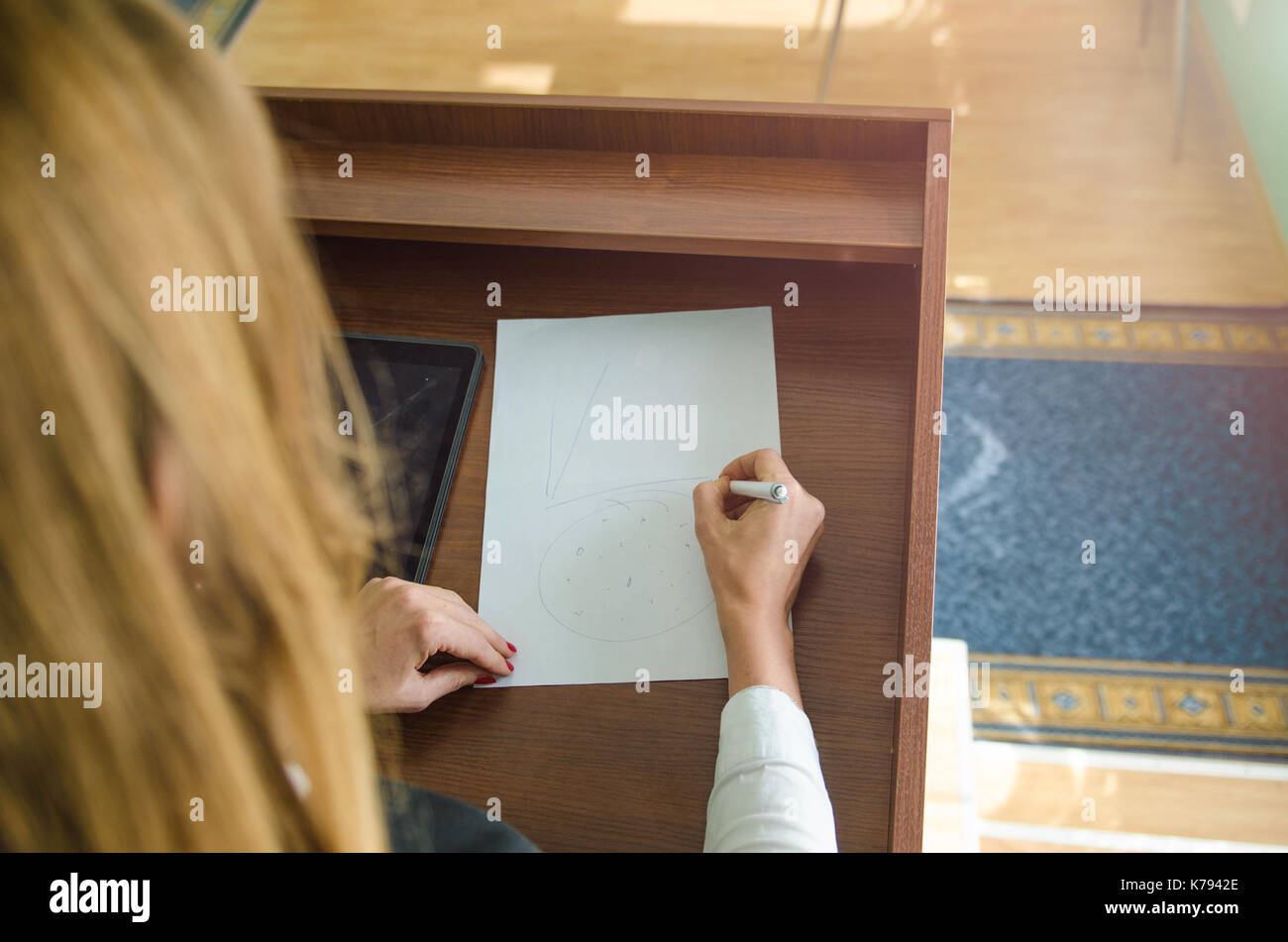 girl with a pen in her hand and a piece of paper Stock Photo - Alamy