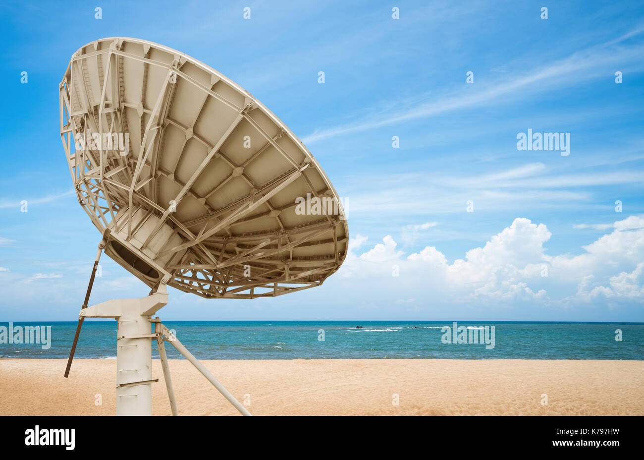 Blue ocean and soft sandy beach, satellite antenna close-up. Stock Photo