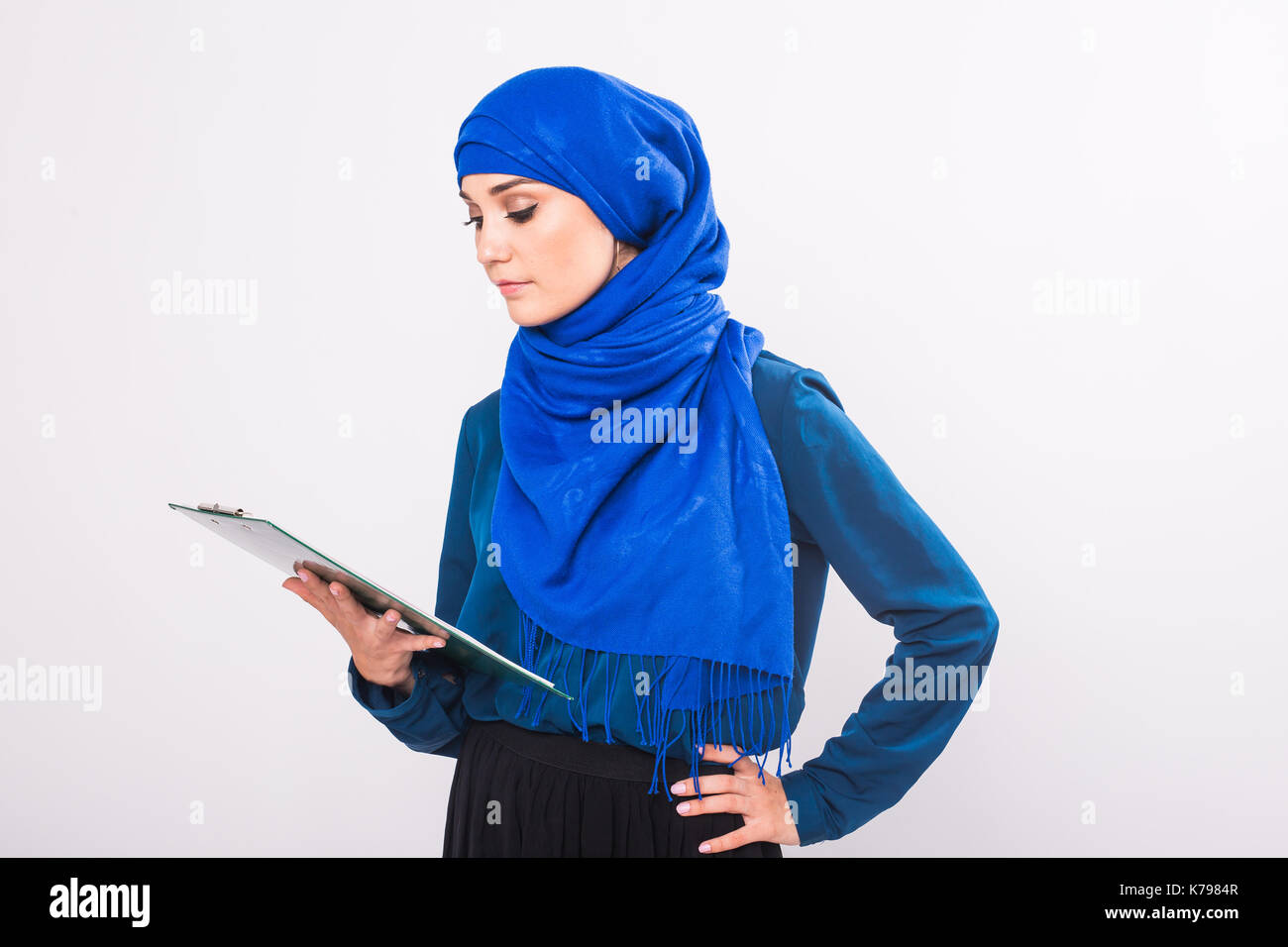 Portrait of beautiful young muslim woman with file folder on a white ...