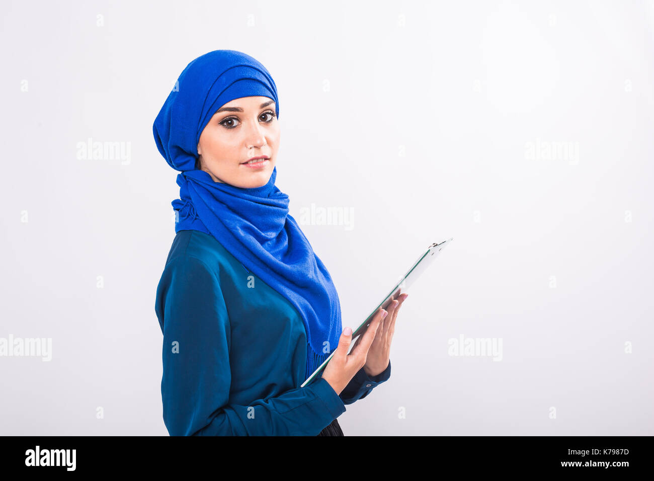 Portrait of beautiful young muslim woman with file folder on a white ...