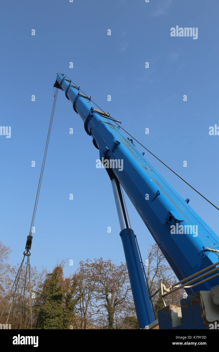 blue hydraulic arm of a powerful crane for lifting heavy loads at an industrial site Stock Photo