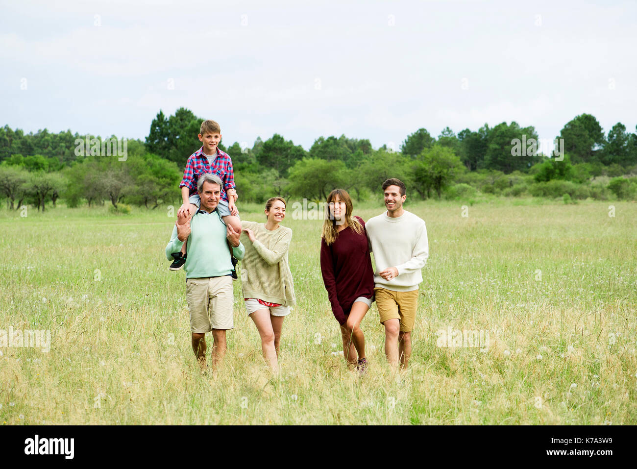 Family walking together through field Stock Photo