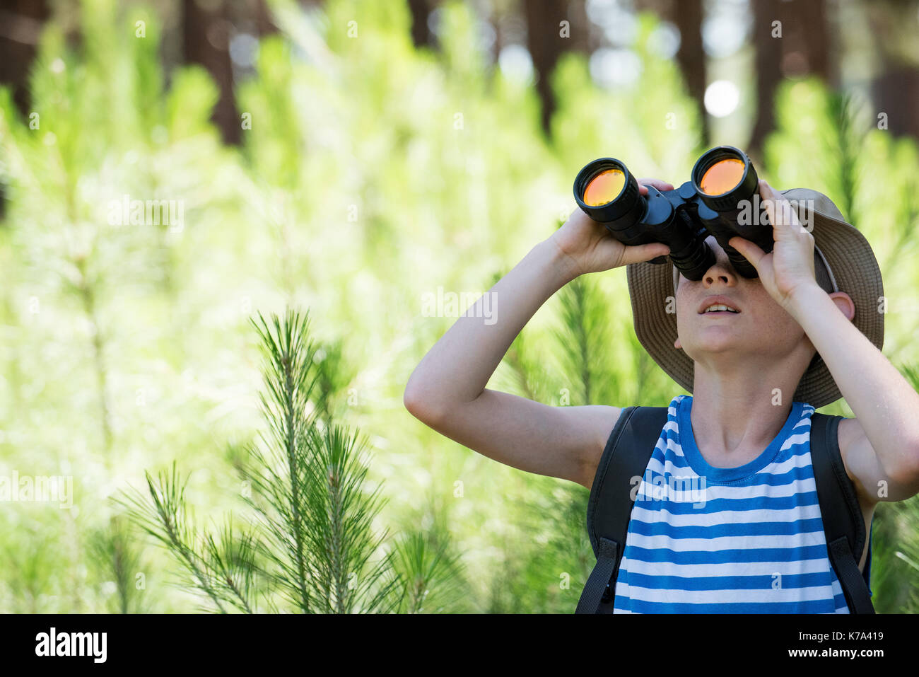 Boy looking through binoculars Stock Photo