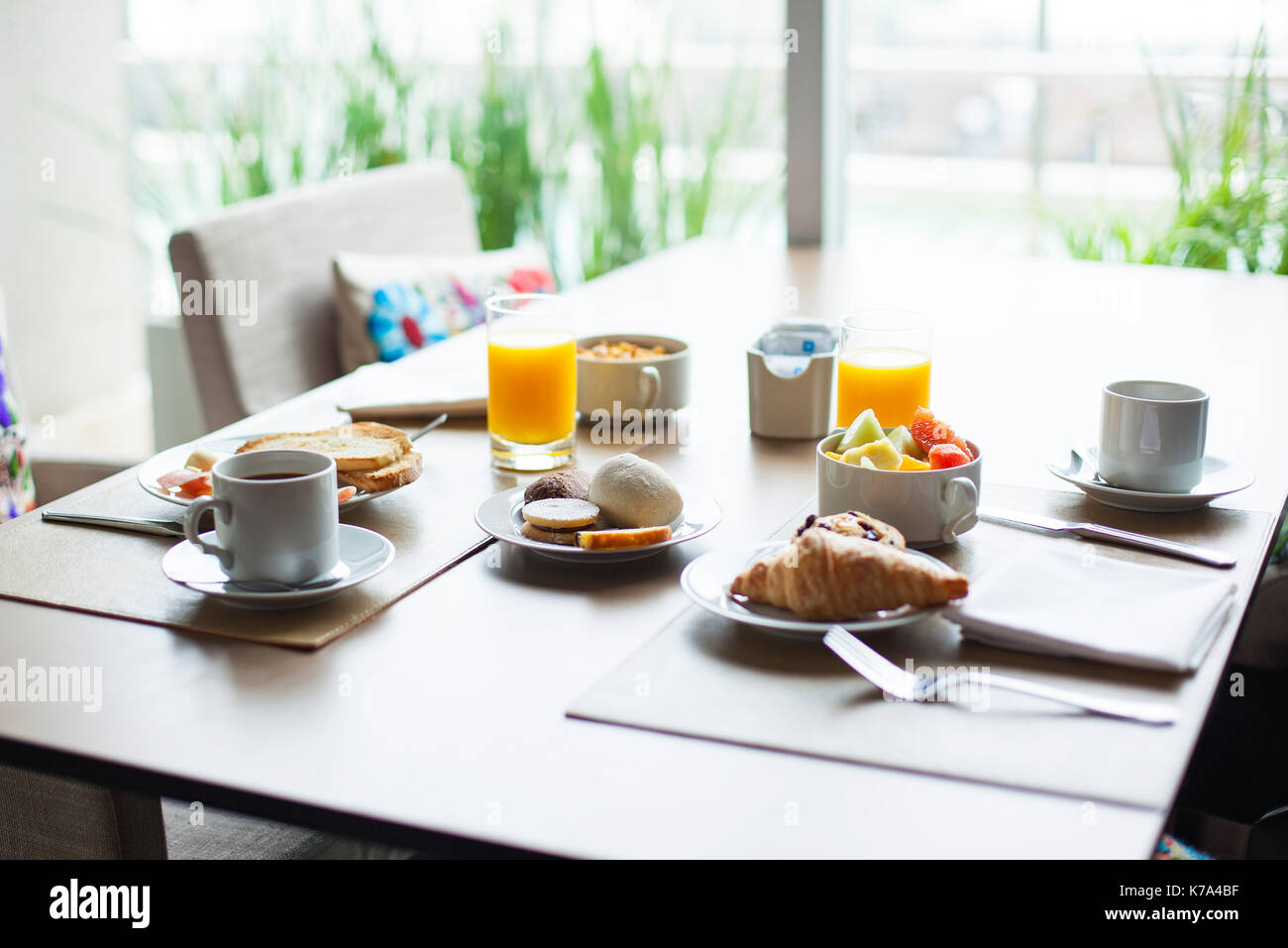 Breakfast of fruit and pastries on cafe table Stock Photo
