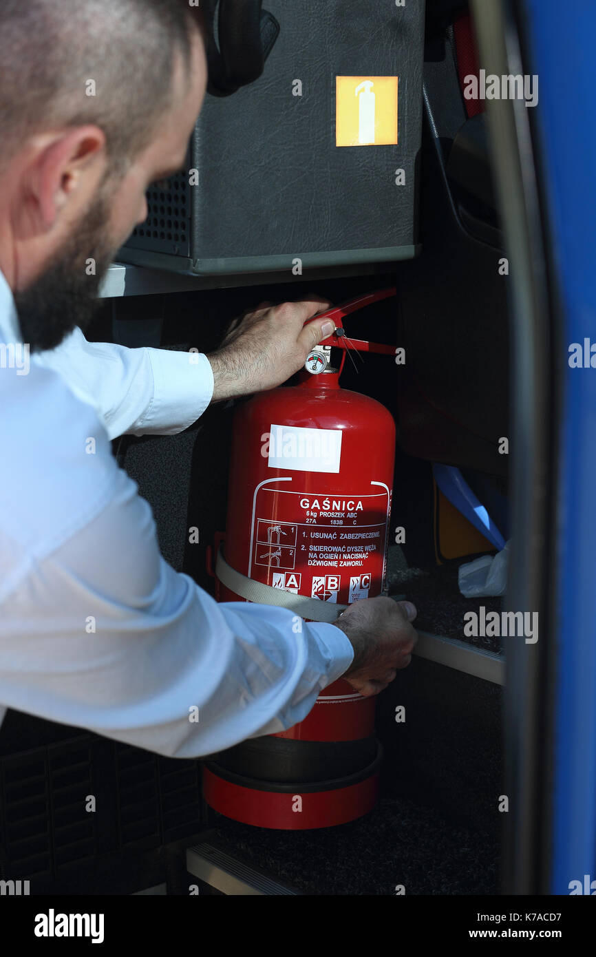 Car fire extinguisher. The bus driver checks the fire extinguisher. Car