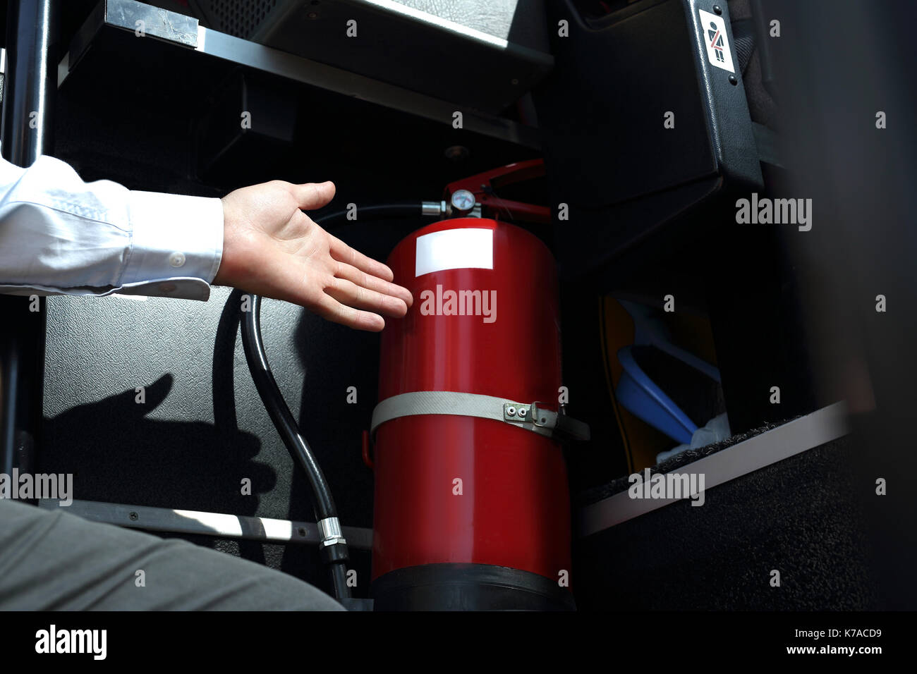 Car fire extinguisher. The bus driver checks the fire extinguisher. Car