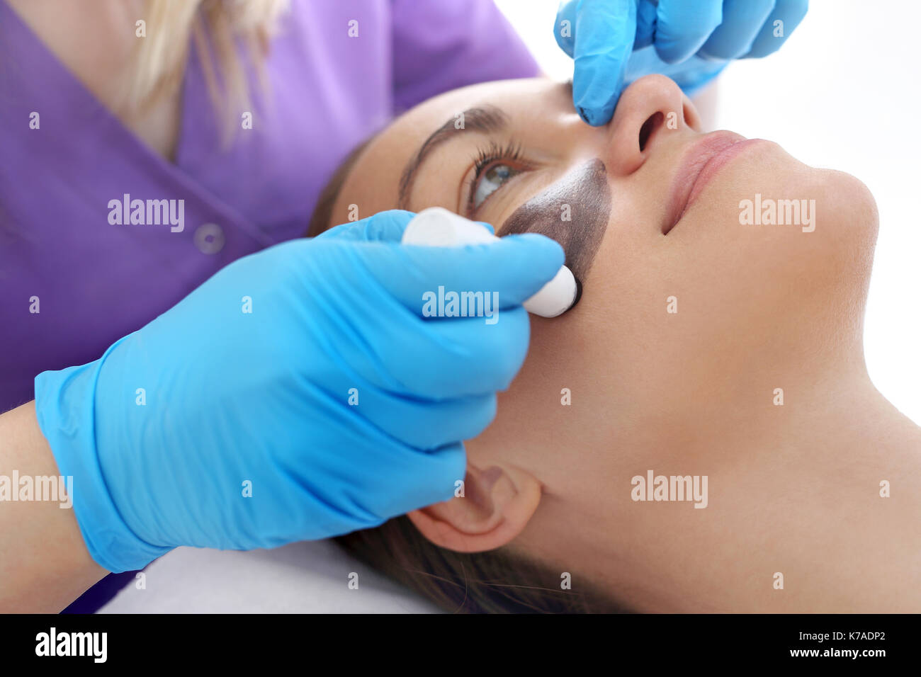 Relaxing facial massage. Woman in beauty parlor during facial massage. Stock Photo