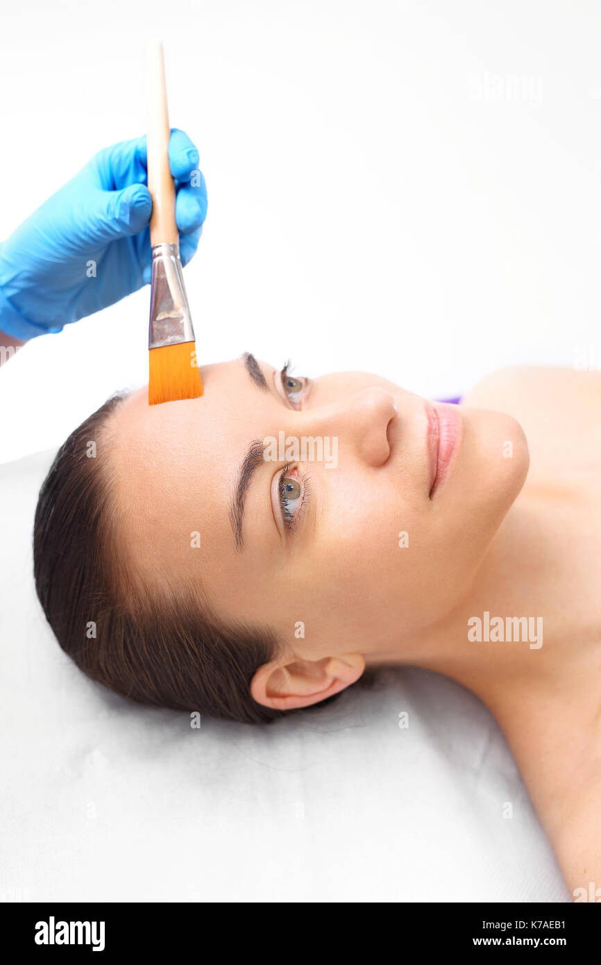 Skin care, cosmetic brush mask is applied to the woman's face. Beautiful healthy skin. In cosmetic surgery cosmetic skin care product is applied with Stock Photo