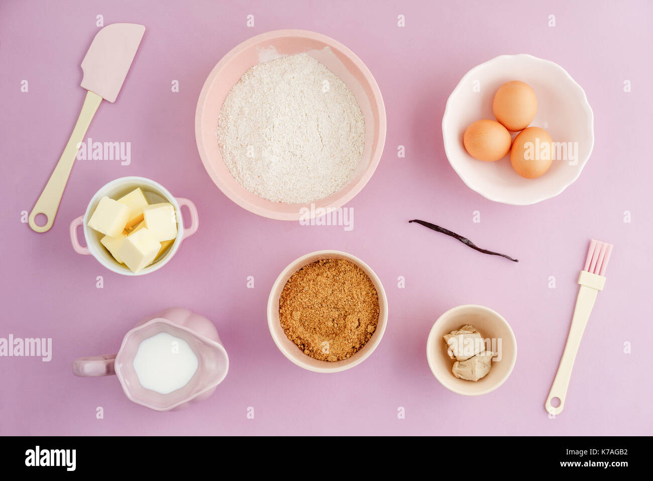 Flatlay collection of tools and ingredients for home baking on pink background shot from above Stock Photo