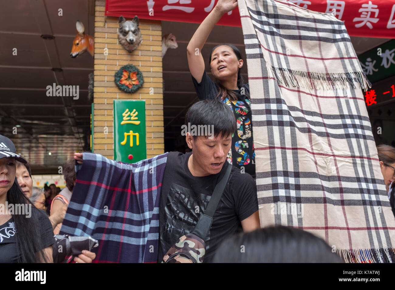 Beijing, China. 15th Sep, 2017. Shopkeepers sell each scarf for 30RMB ( $4.5 ) as a closing down sale on the last day before the closure of a wholesale market in central Beijing, China. Tianyi Market is the latest wholesale market closes its doors after 25 years of operating and some 1,500 shops are forced out in Beijing. Beijing is hoping to get rid of all wholesale markets within its Fourth Ring Road by 2020 in order to reduce its population by 15 percent, a total of some two million people, by 2020. Credit: Lou Linwei/Alamy Live News Stock Photo
