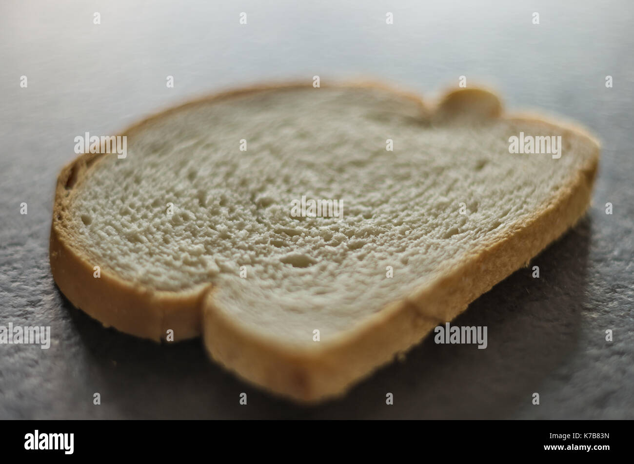 Slice of bread on top of black granite top Stock Photo