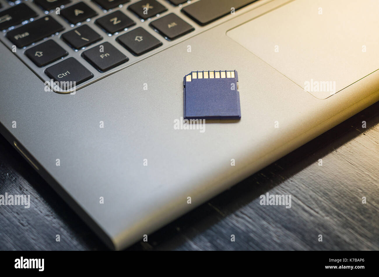 SD memory card on top of computer. Stock Photo