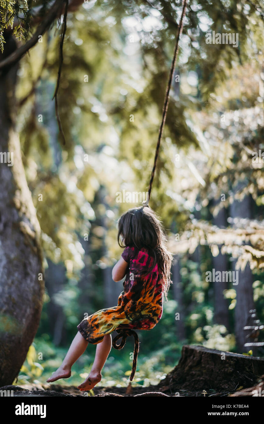 Girl swinging on rope swing at forest Stock Photo Alamy