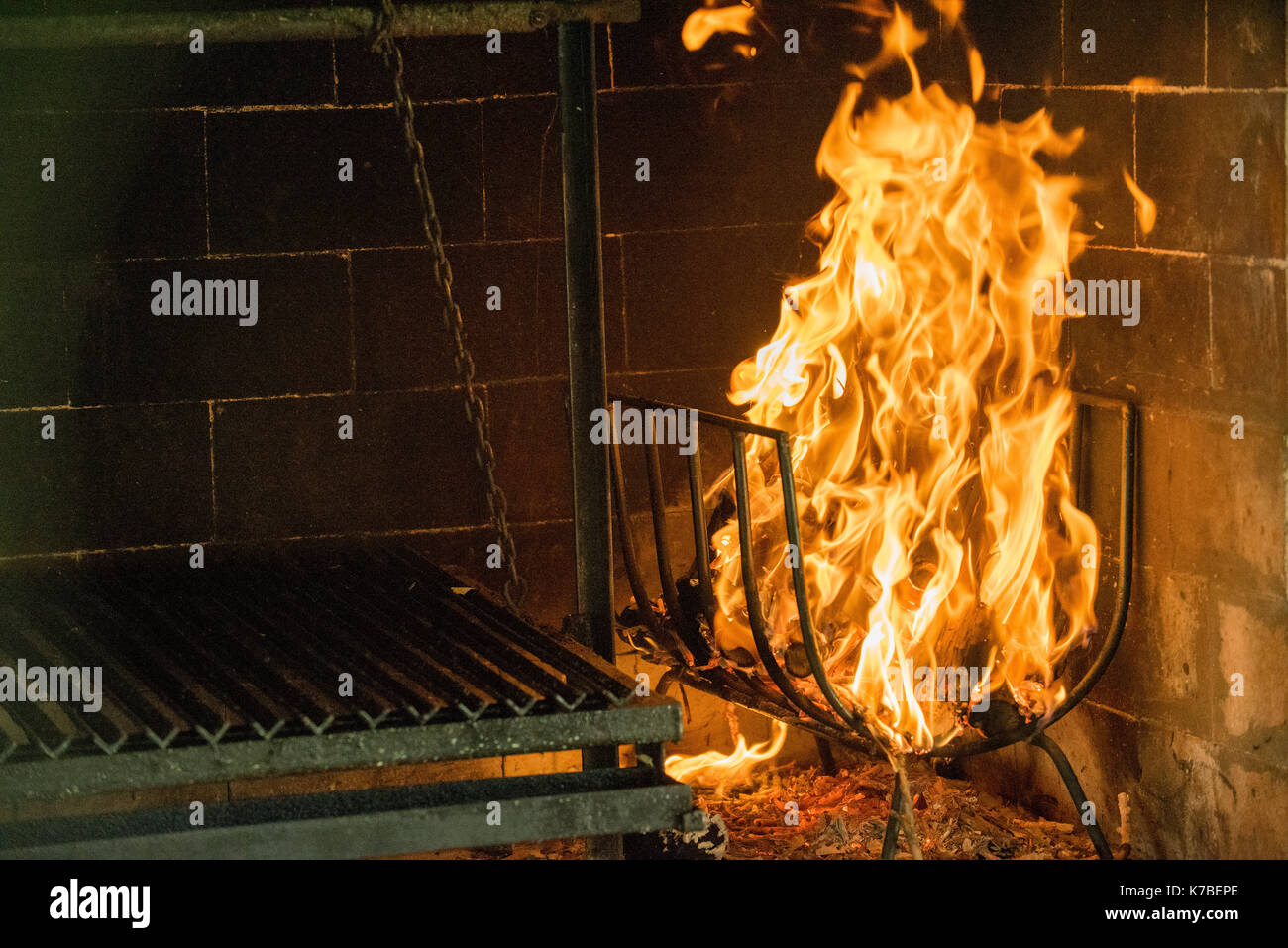Fire burning beside grill in fireplace Stock Photo