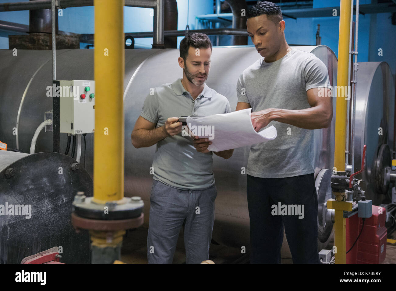 Men working in industrial setting Stock Photo