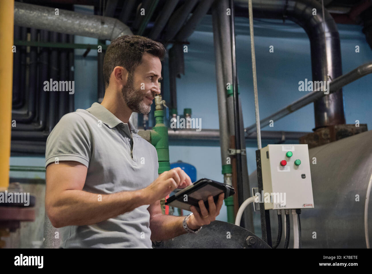 Man using digital tablet in industrial setting Stock Photo