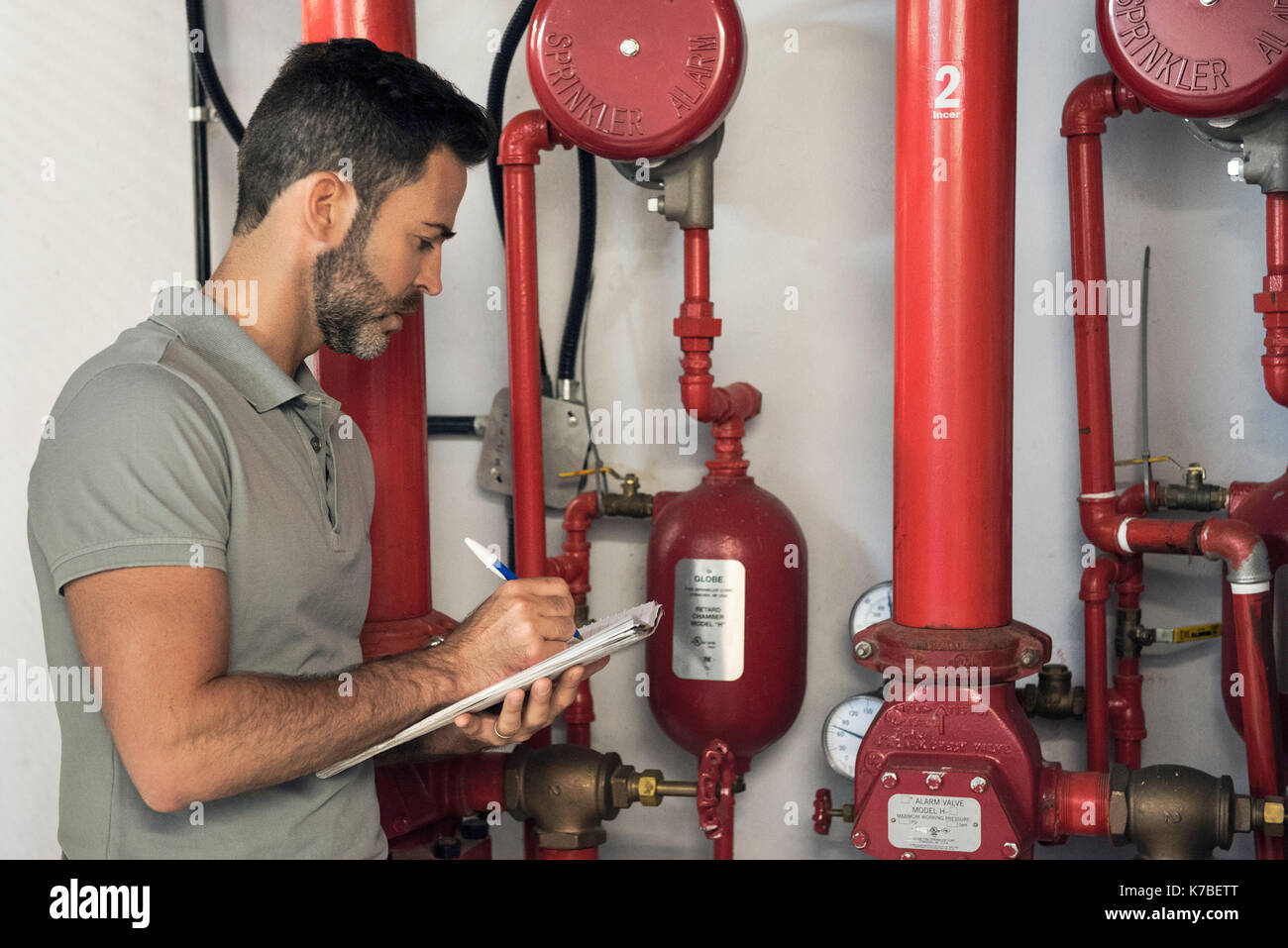Man inspecting fire protection sprinkler system Stock Photo
