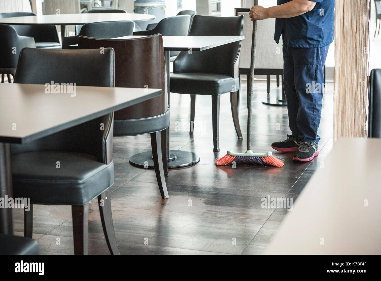 Man sweeping restaurant floor Stock Photo