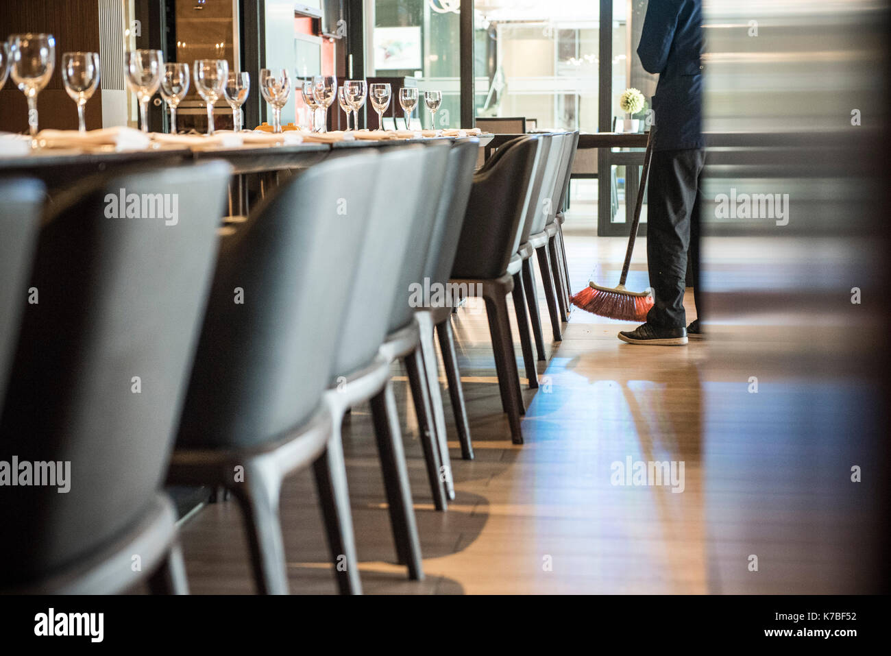 Person sweeping restaurant floor Stock Photo